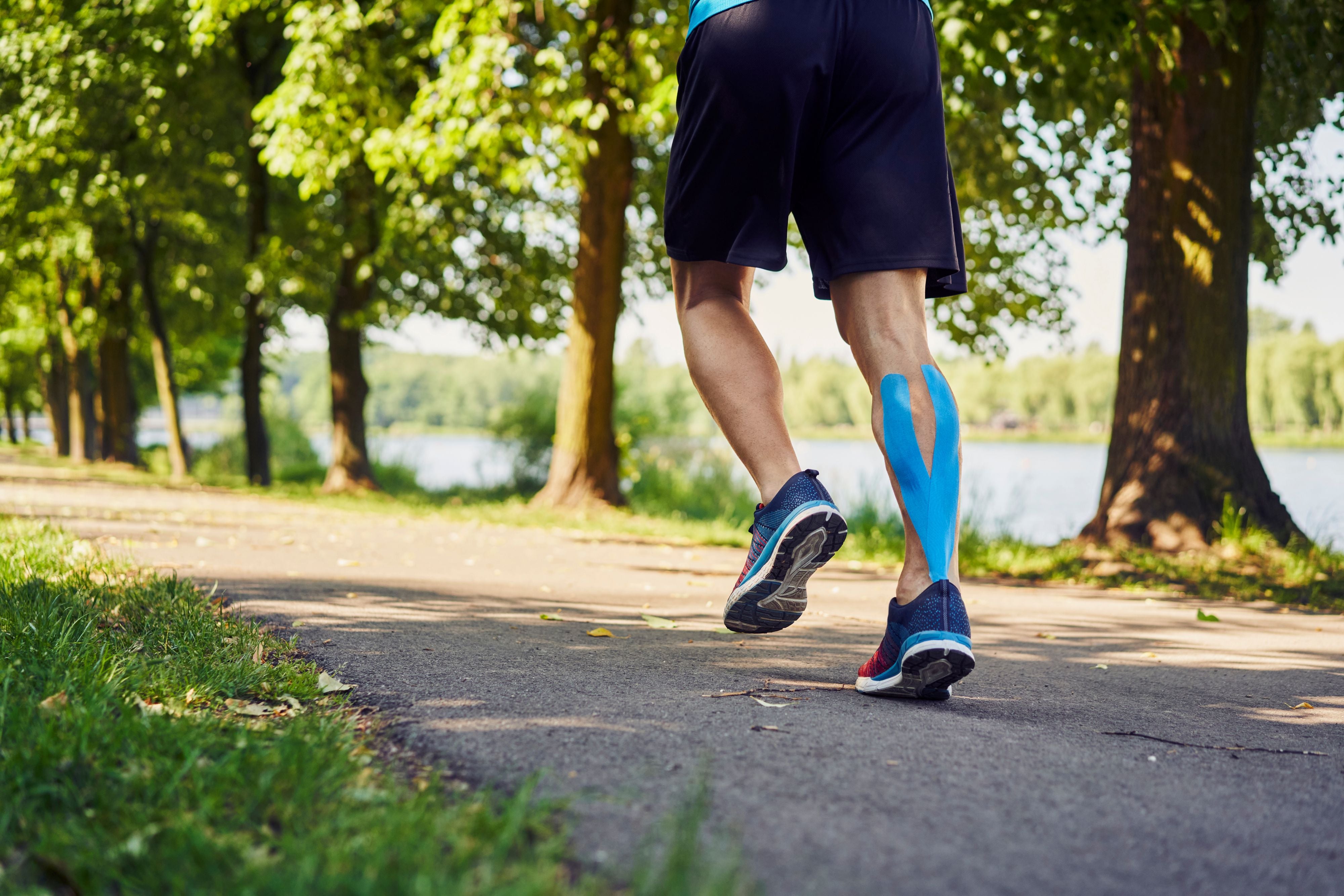 Person running on a path with trees and water in the background