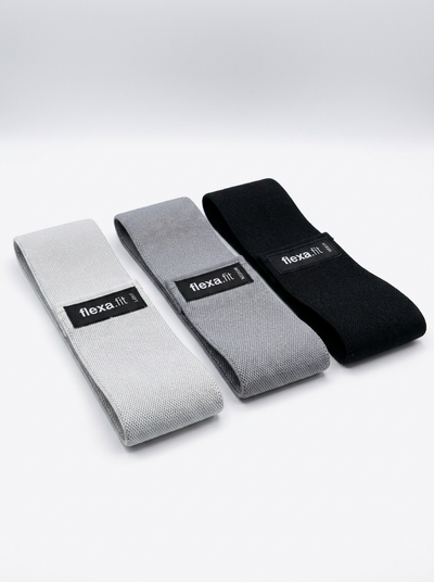 Studio shot of flexa.fit fabric glute resistance bands in light grey, dark grey and black