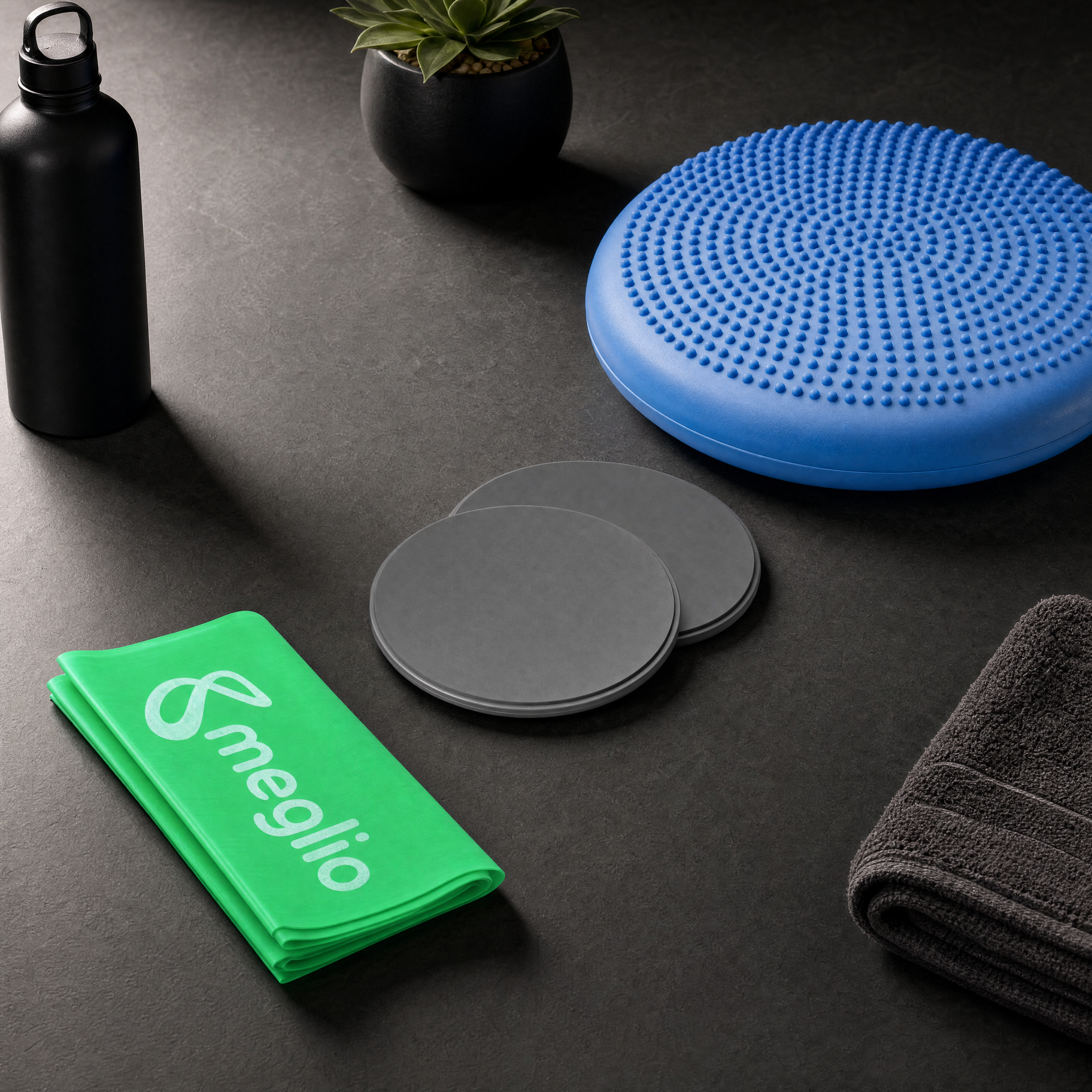 flexa.fit Core and Balance Kit on a dark surface, the wobble cushion with core sliders and a resistance band