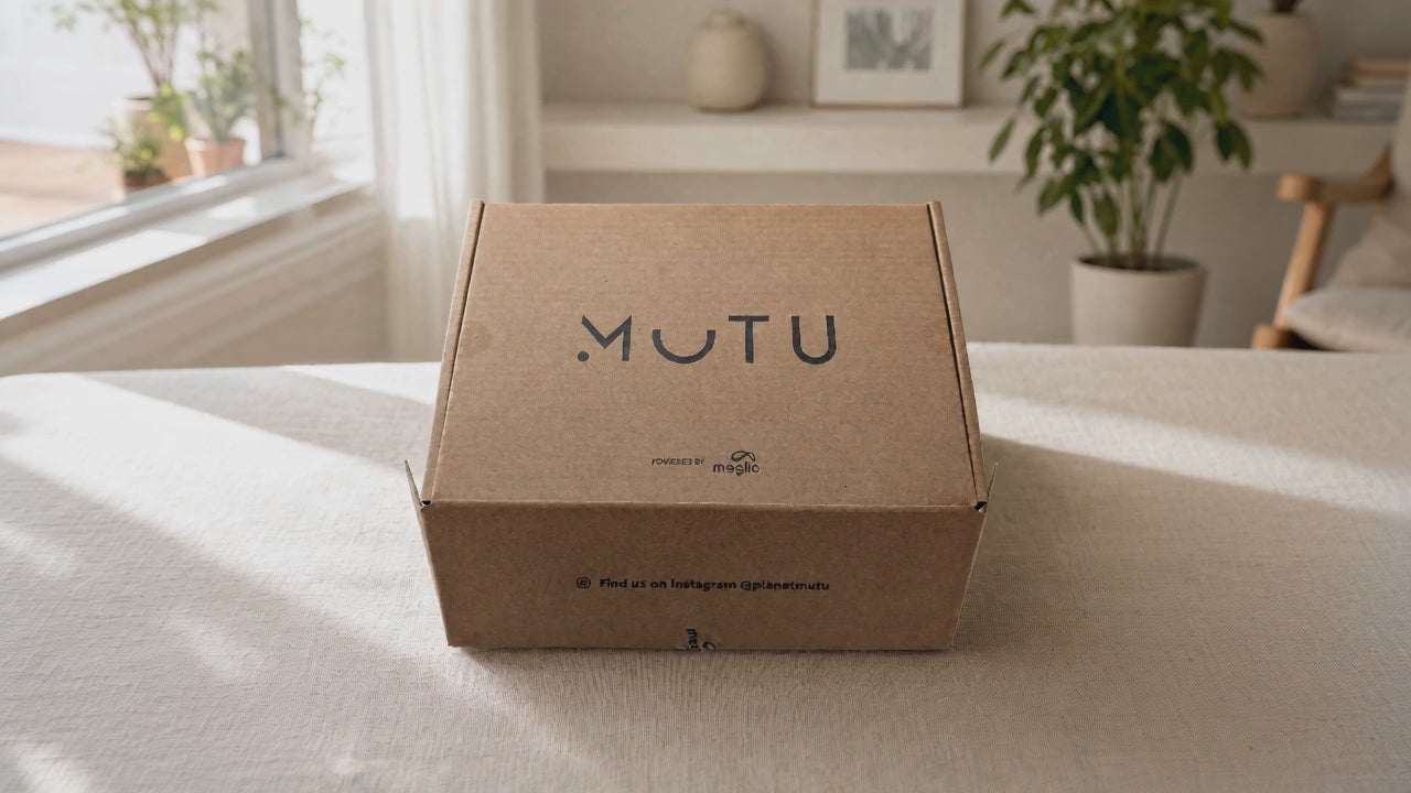 Load video: The MUTU Pack box on a living room floor beside a rolled yoga mat